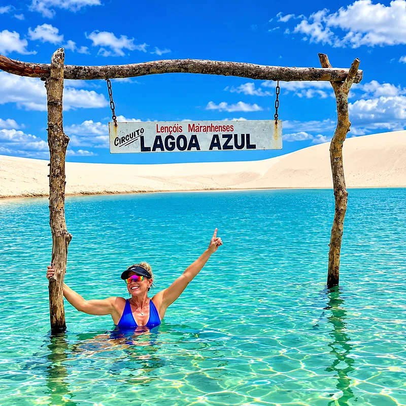 Lagoa de água azul entre dunas brancas